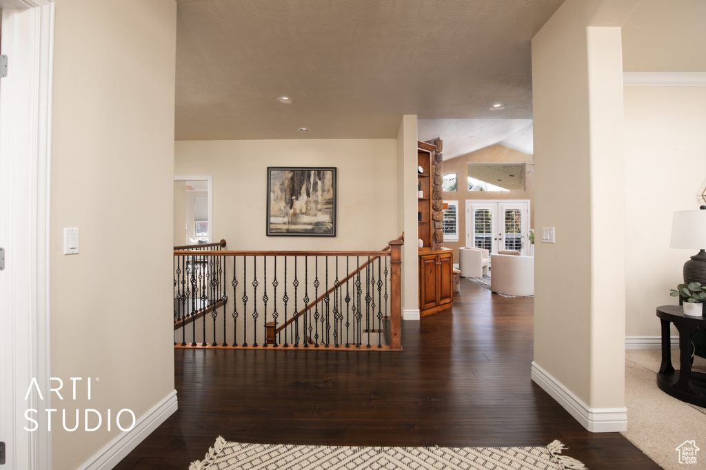 Hallway with dark hardwood / wood-style flooring, french doors, and lofted ceiling