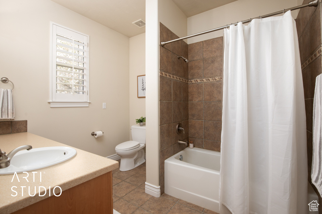 Full bathroom with shower / tub combo, tile flooring, toilet, and vanity
