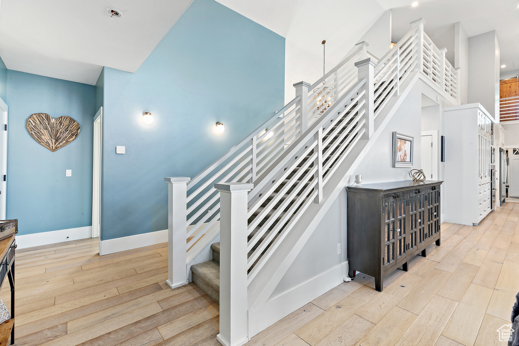 Staircase with light hardwood / wood-style flooring