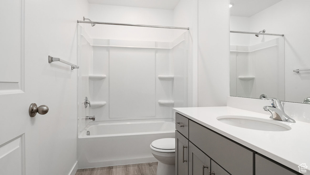 Full bathroom with vanity, toilet, bathing tub / shower combination, and hardwood / wood-style floors