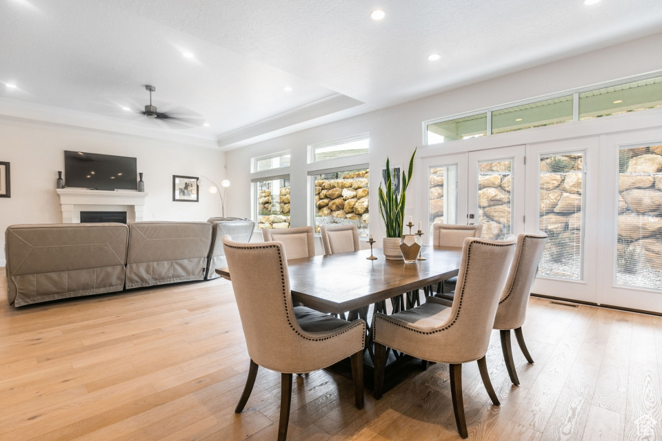 Dining space with a raised ceiling, a wealth of natural light, and light hardwood / wood-style floors