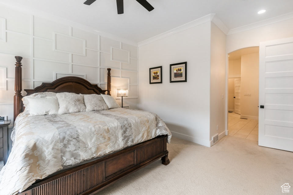 Bedroom featuring ceiling fan, crown molding, and light colored carpet