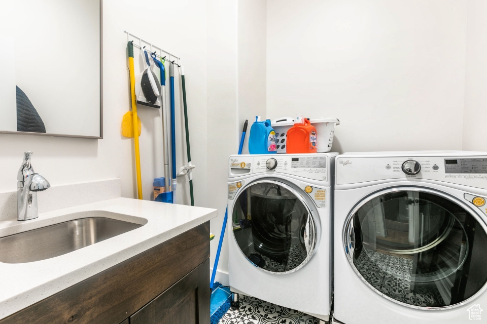 Laundry room with light tile floors, sink, and washer and dryer