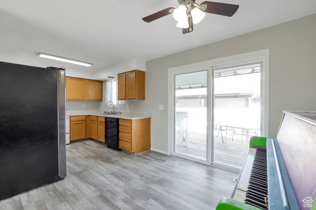 Kitchen featuring ceiling fan, fridge, dishwasher, sink, and light hardwood / wood-style flooring