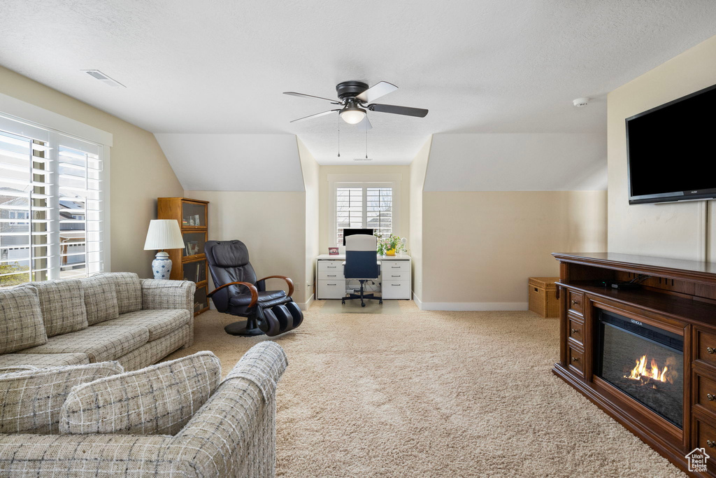 Living room featuring ceiling fan, light colored carpet, and vaulted ceiling
