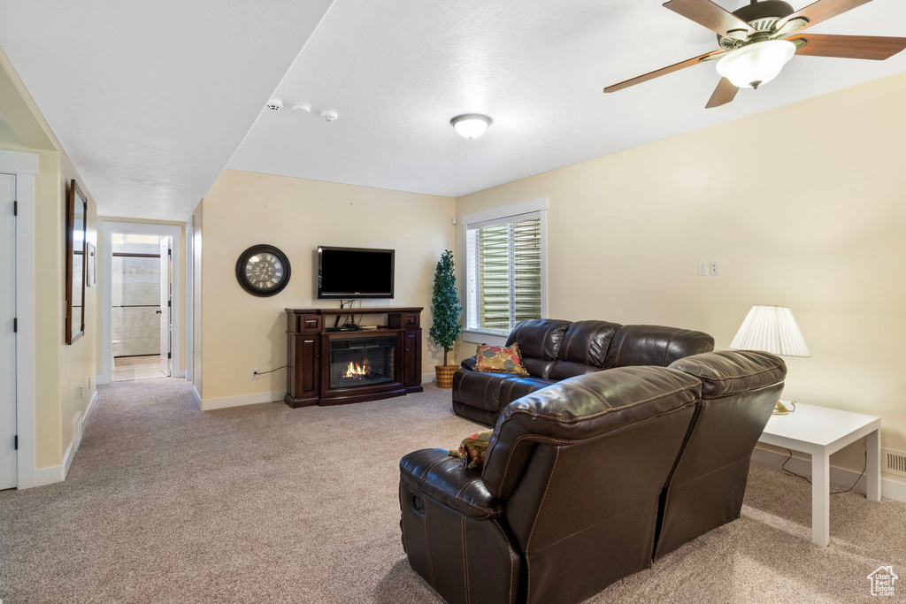 Living room featuring light colored carpet and ceiling fan