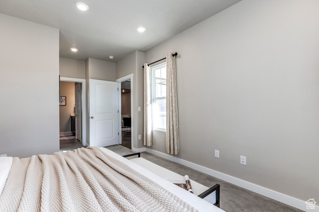 Bedroom featuring connected bathroom and light colored carpet