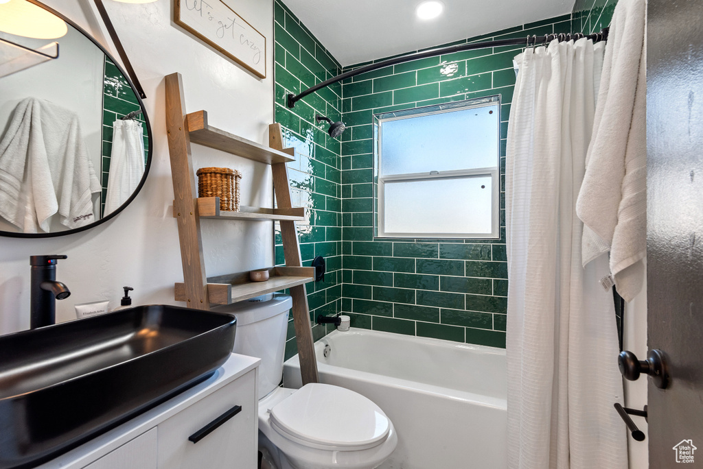 Full bathroom with shower / bath combo with shower curtain, toilet, and large vanity