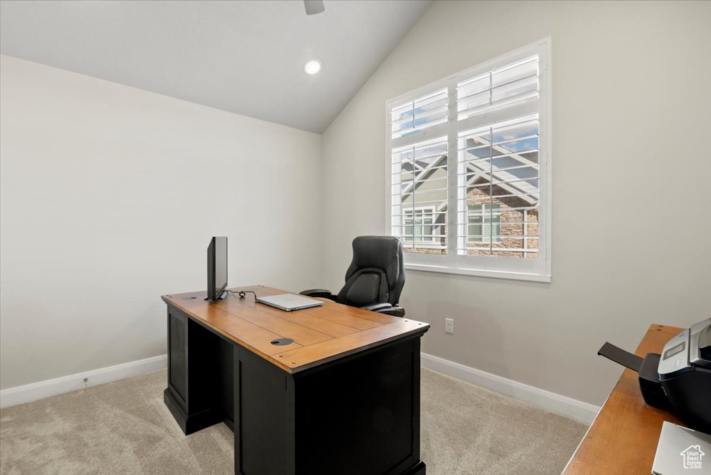 Office with vaulted ceiling, light carpet, and a healthy amount of sunlight
