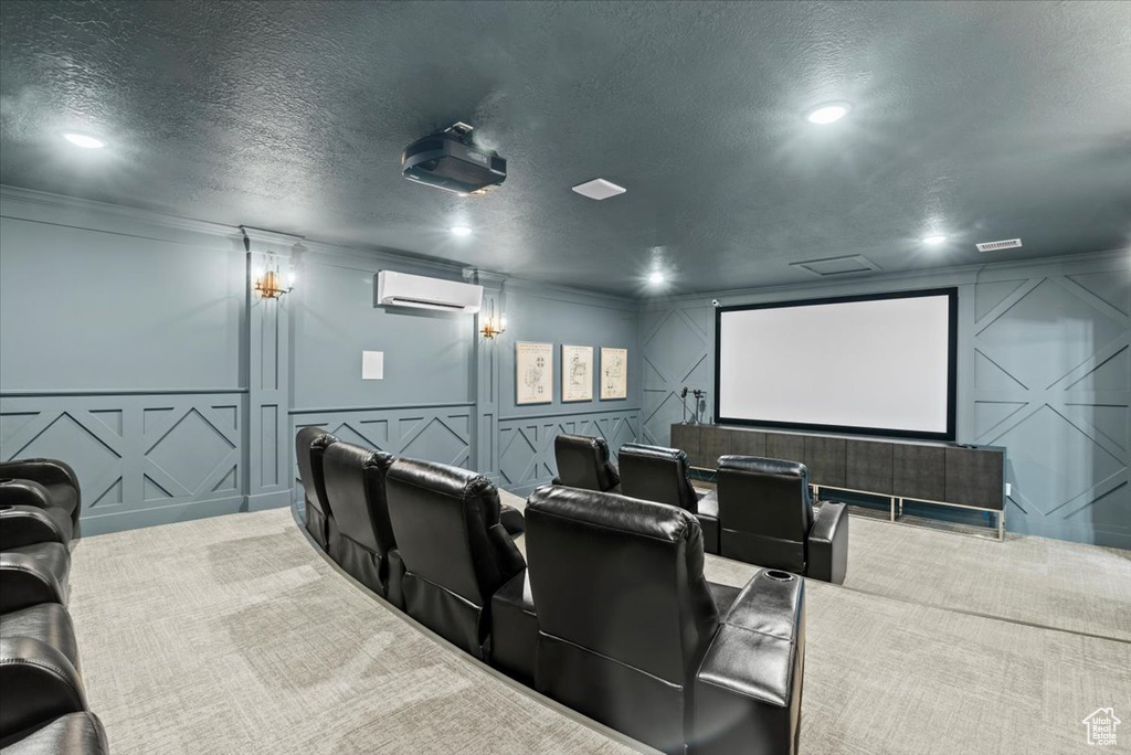 Carpeted home theater room featuring a wall mounted AC and a textured ceiling