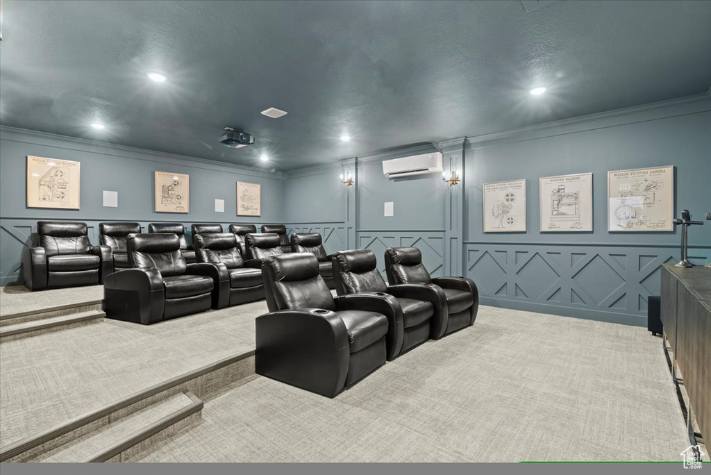 Home theater room featuring a wall unit AC, crown molding, and light colored carpet