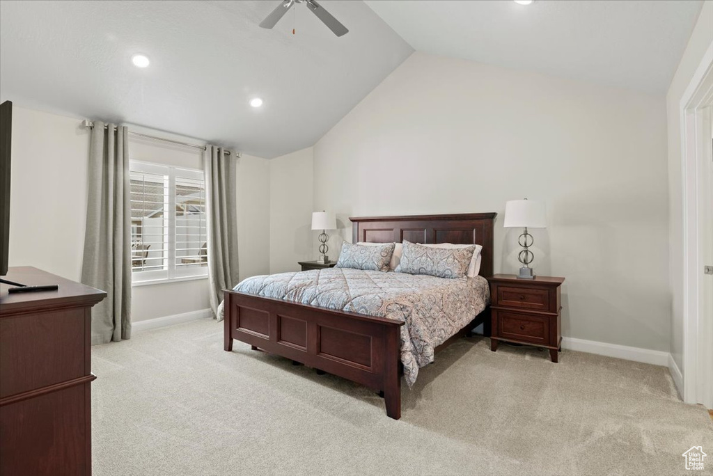 Bedroom with ceiling fan, lofted ceiling, and light carpet