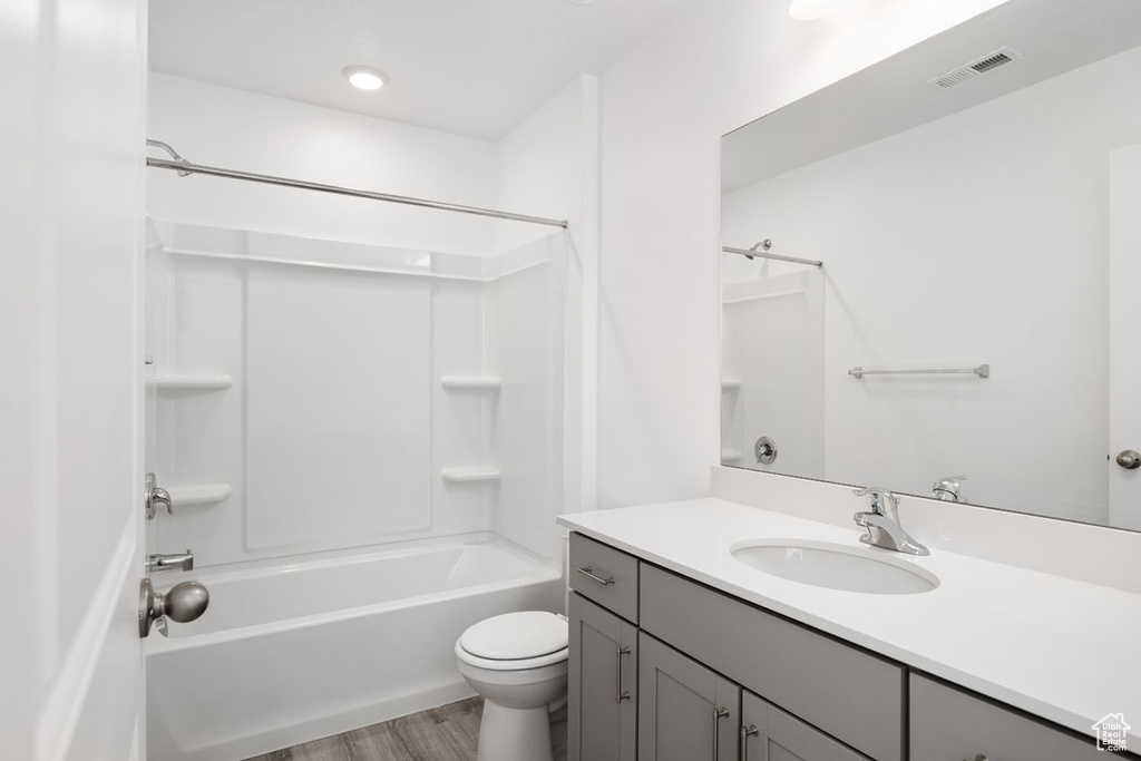 Full bathroom featuring shower / bathing tub combination, toilet, hardwood / wood-style floors, and vanity