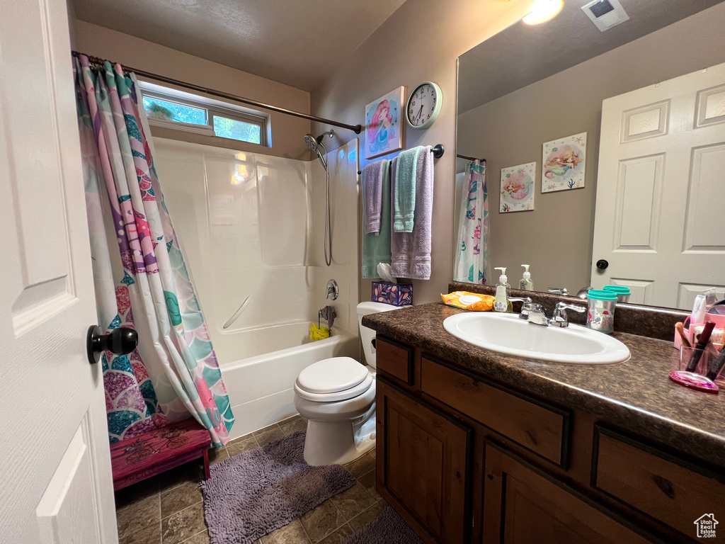 Full bathroom featuring shower / tub combo, tile flooring, large vanity, and toilet
