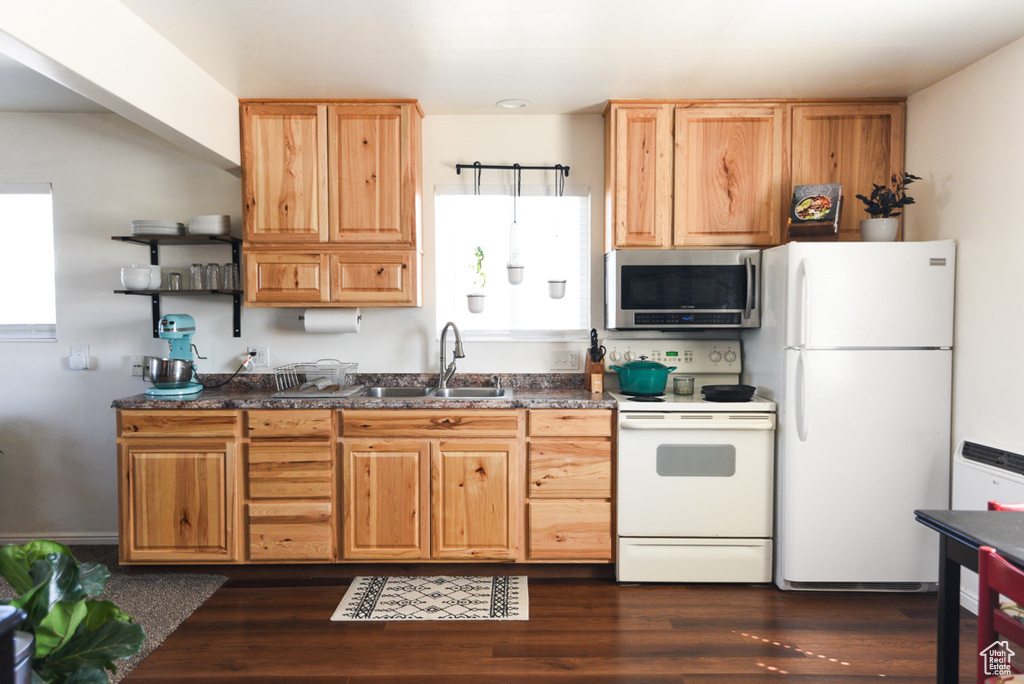 Kitchen featuring white appliances, dark wood-type flooring, sink, and plenty of natural light