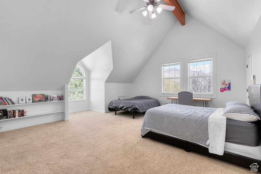 Carpeted bedroom featuring ceiling fan and lofted ceiling with beams
