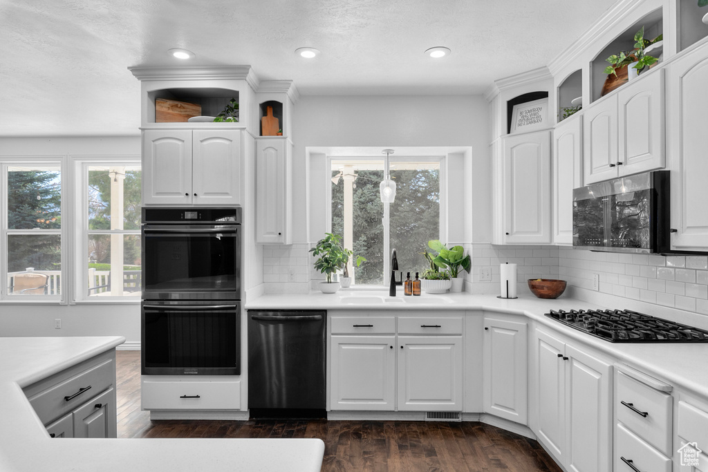 Kitchen with sink, dark hardwood / wood-style flooring, stainless steel appliances, and backsplash