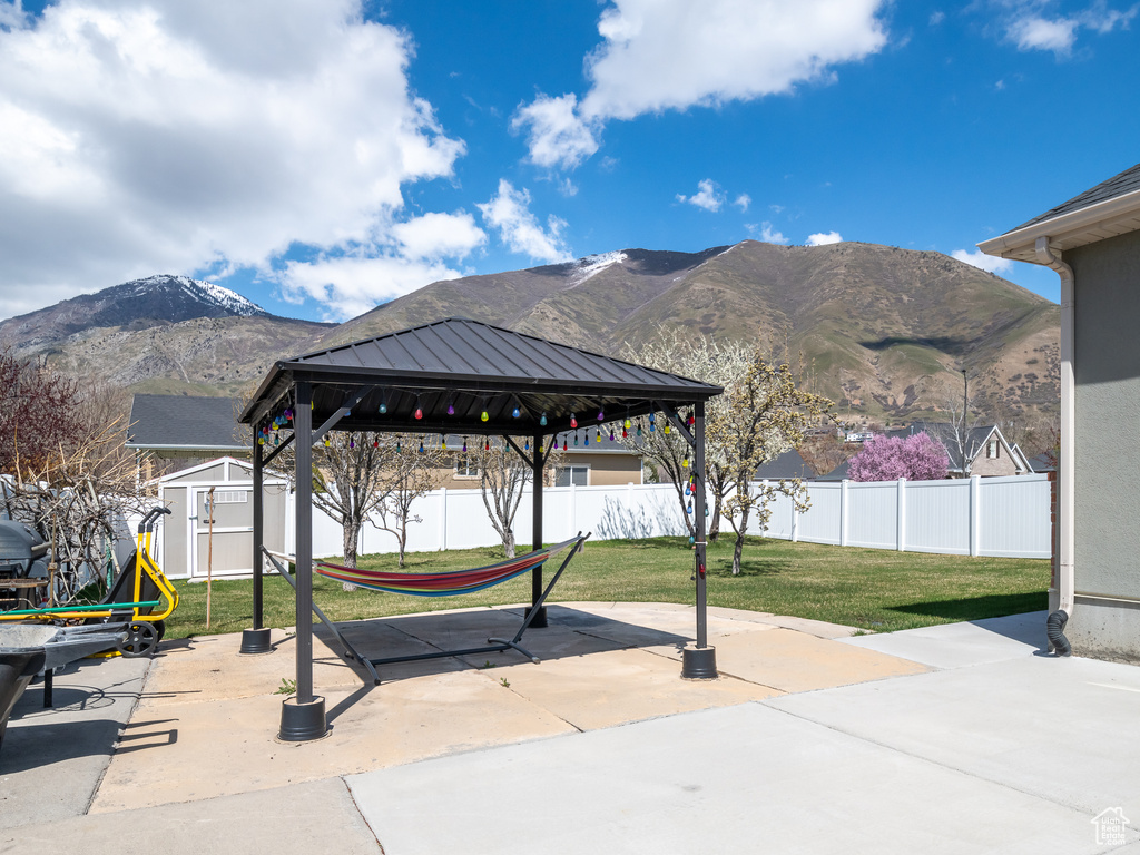 View of nearby features with a patio area, a yard, a mountain view, a gazebo, and a storage shed