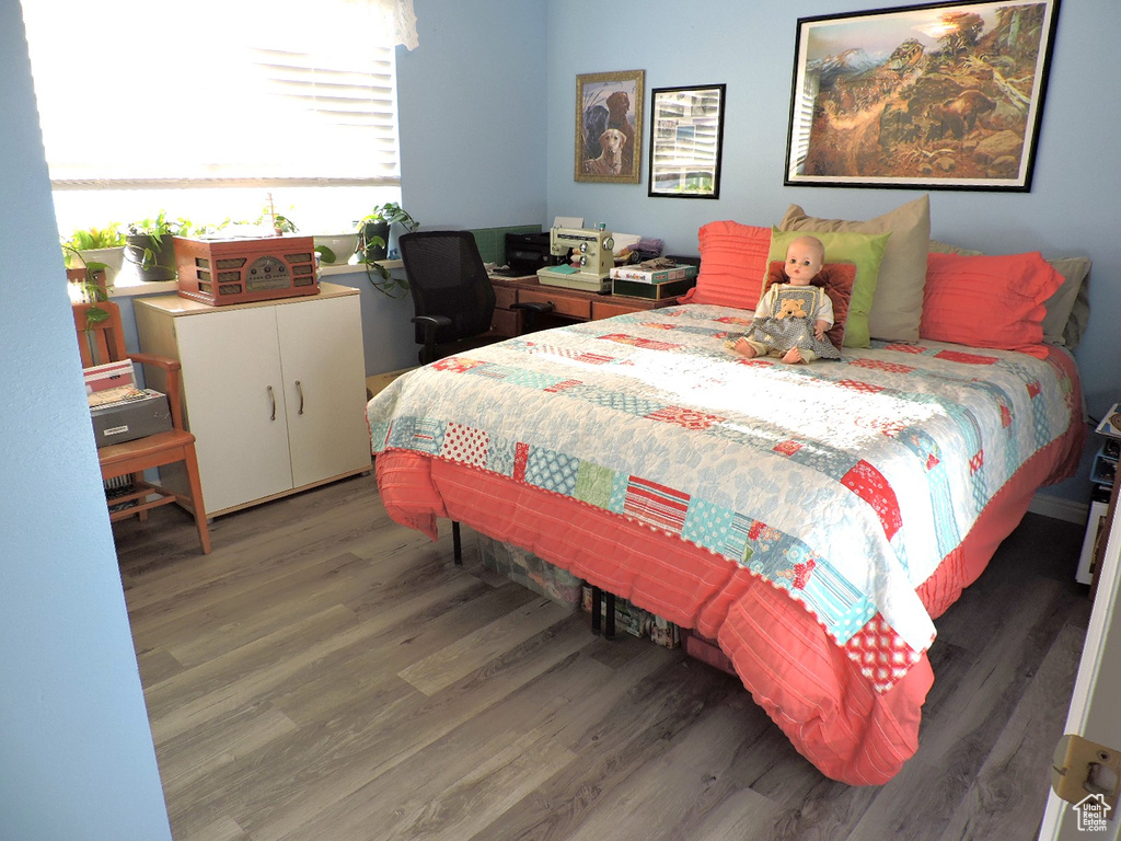 Bedroom with dark hardwood / wood-style flooring
