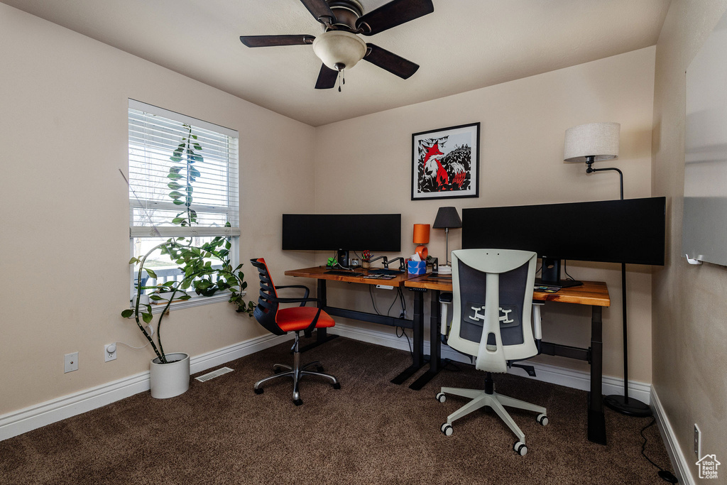 Carpeted office featuring ceiling fan