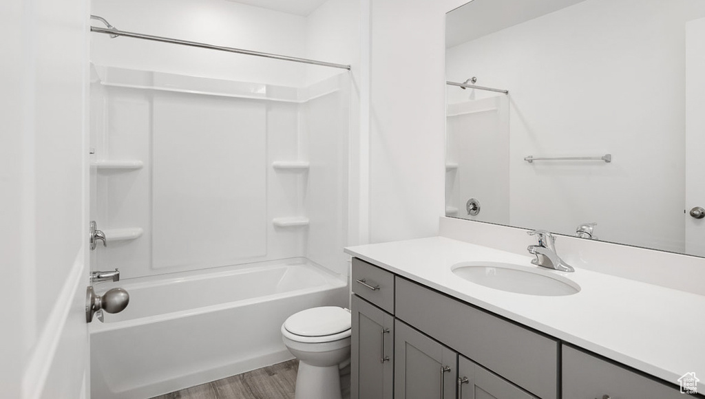 Full bathroom featuring toilet, washtub / shower combination, vanity, and wood-type flooring