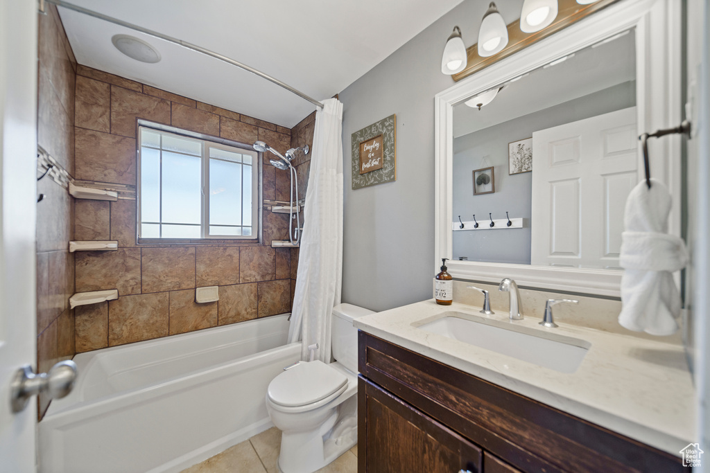 Full bathroom featuring toilet, large vanity, tile flooring, and shower / bath combo