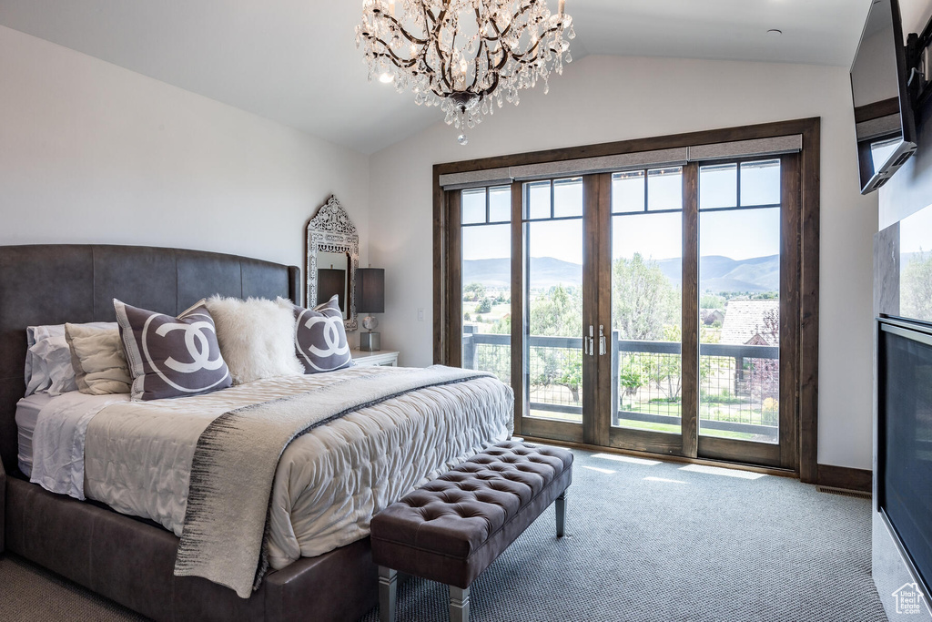 Bedroom featuring multiple windows, an inviting chandelier, and vaulted ceiling
