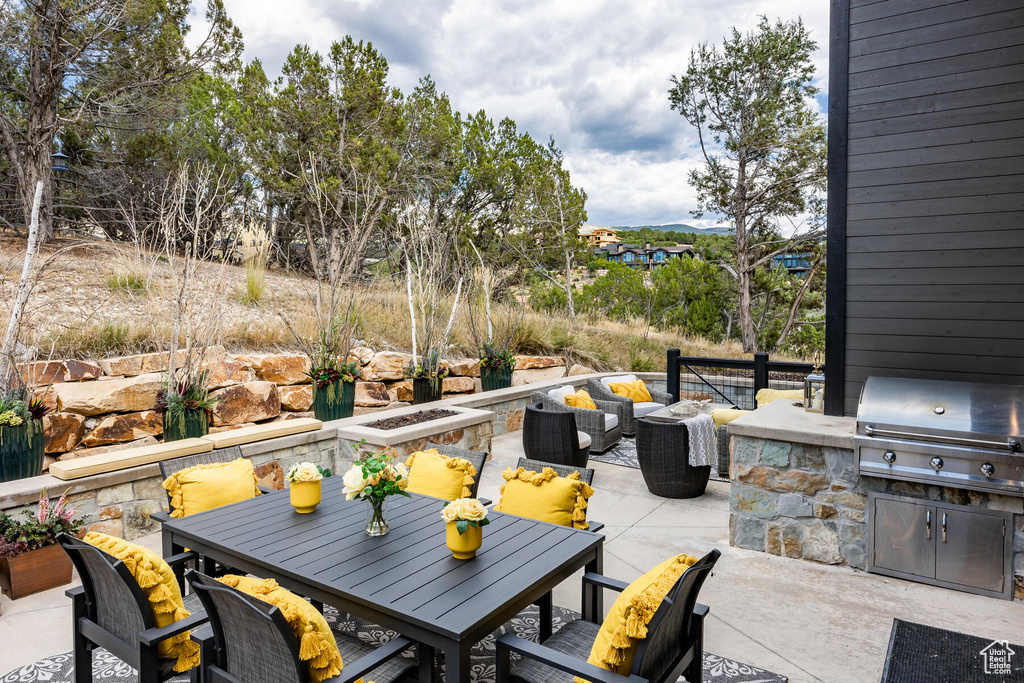 View of terrace with a grill, an outdoor kitchen, and an outdoor living space with a fire pit