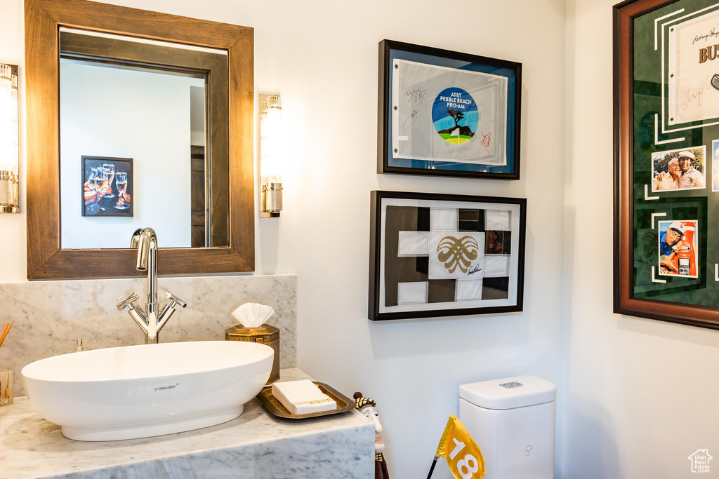 Bathroom featuring backsplash, toilet, and sink