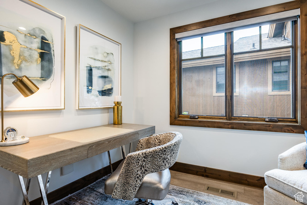 Office space with dark hardwood / wood-style flooring