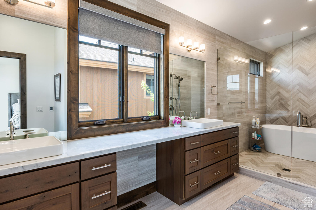 Bathroom with tile walls, vanity, and an enclosed shower
