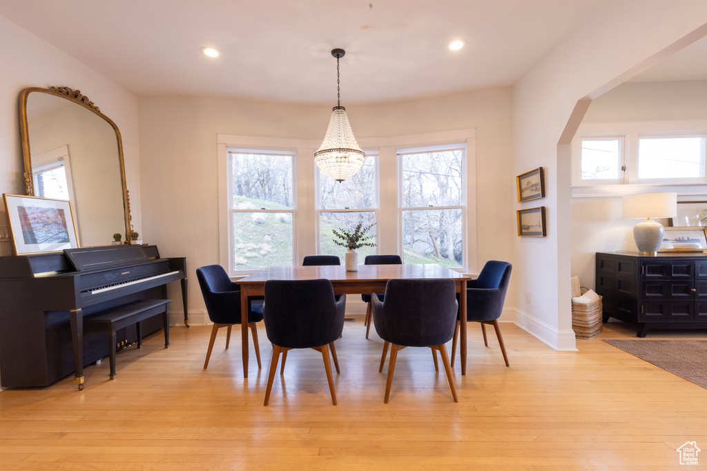 Dining room featuring an inviting chandelier, light hardwood / wood-style floors, and a wealth of natural light