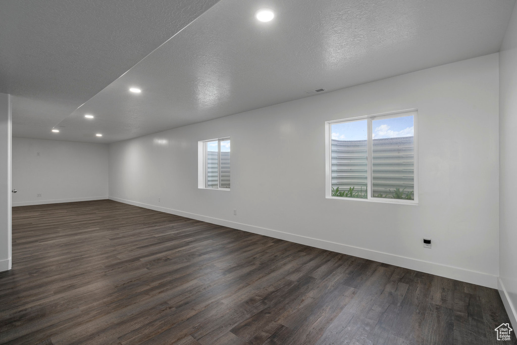 Spare room with dark hardwood / wood-style flooring and a textured ceiling