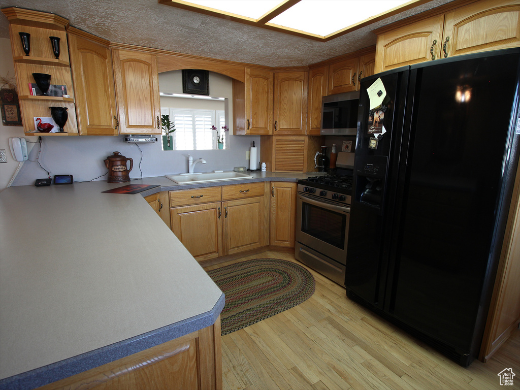 Kitchen featuring sink, light hardwood / wood-style floors, and stainless steel appliances