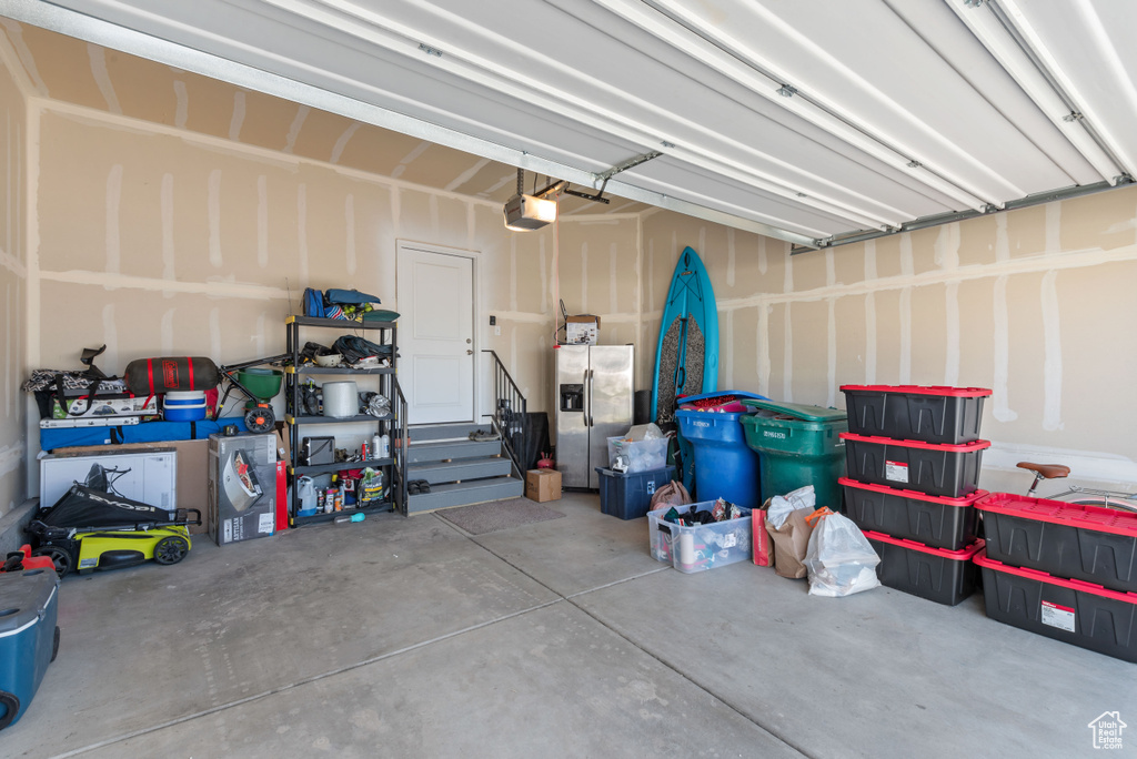 Garage with a garage door opener and stainless steel fridge