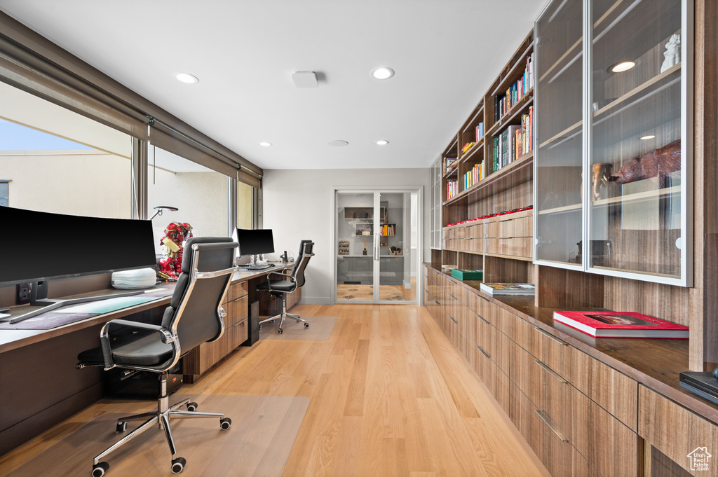Office space with plenty of natural light and light hardwood / wood-style flooring