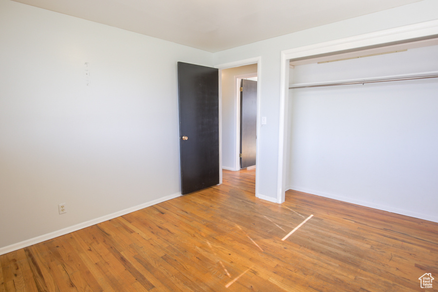 Unfurnished bedroom featuring a closet and hardwood / wood-style flooring