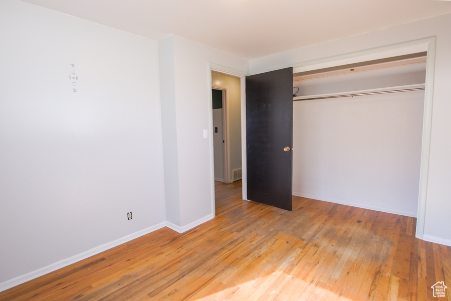 Unfurnished bedroom with a closet and light hardwood / wood-style floors