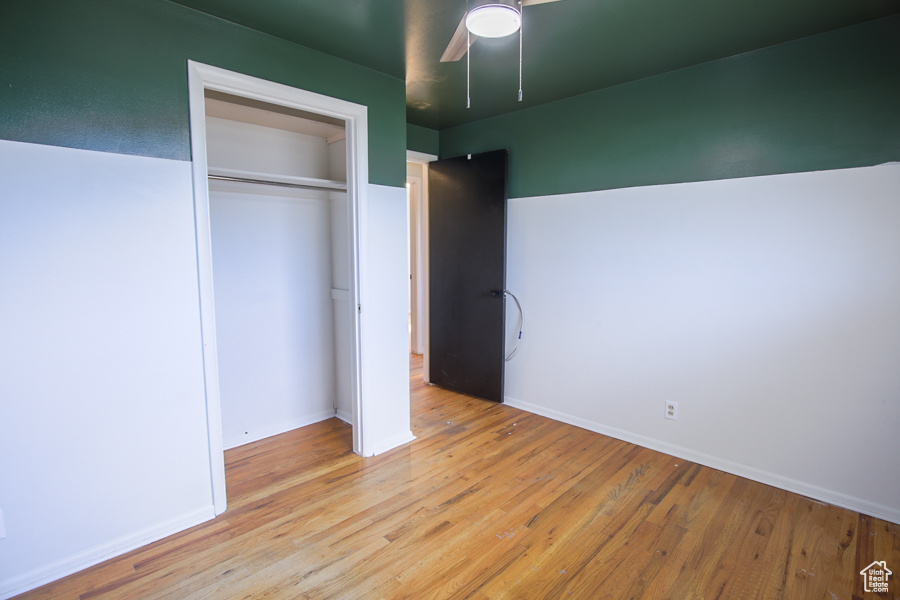 Unfurnished bedroom featuring a closet, light hardwood / wood-style flooring, and ceiling fan
