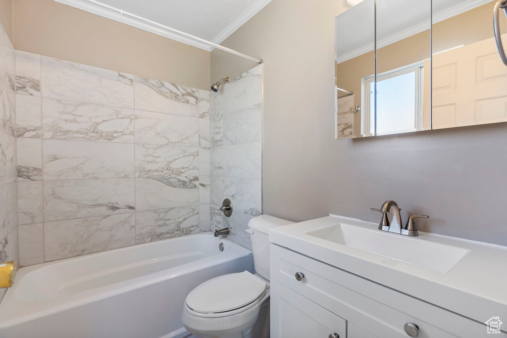Full bathroom featuring ornamental molding, tiled shower / bath combo, toilet, and vanity