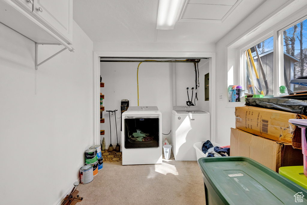 Laundry room with separate washer and dryer and light colored carpet