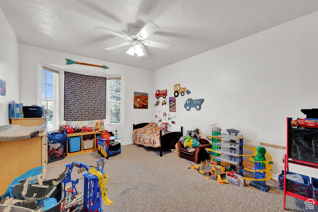 Game room featuring carpet flooring, a textured ceiling, and ceiling fan