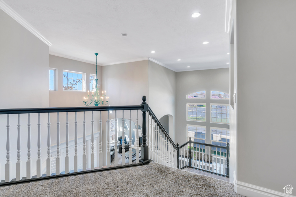 Stairs featuring carpet floors, crown molding, and an inviting chandelier
