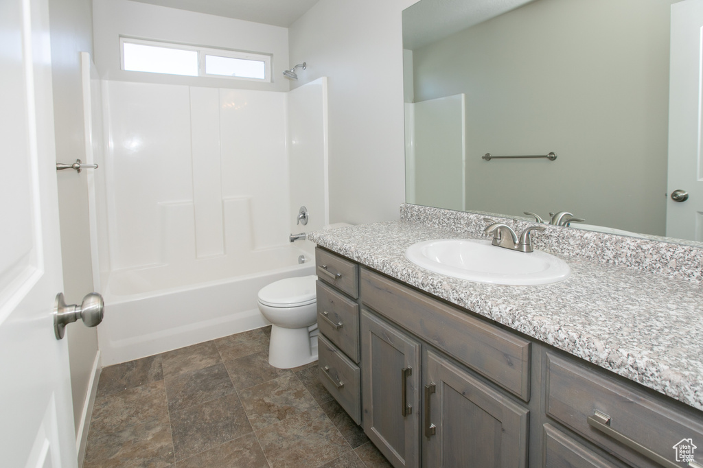 Full bathroom featuring washtub / shower combination, toilet, vanity, and tile floors