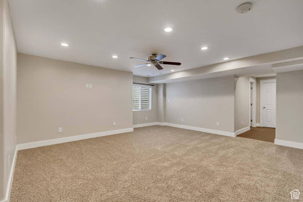 Unfurnished room with ceiling fan and dark carpet