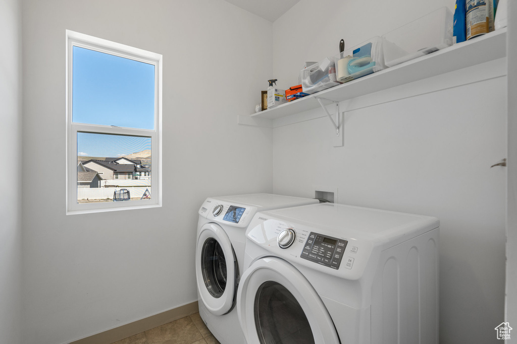 Laundry room featuring light tile flooring, washer hookup, and separate washer and dryer
