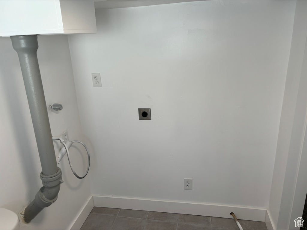 Clothes washing area with hookup for an electric dryer and dark tile flooring