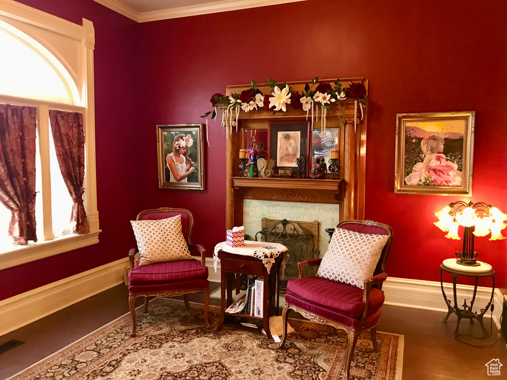 Sitting room with ornamental molding and wood-type flooring