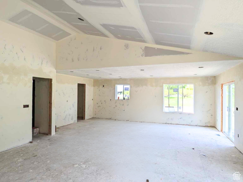 Empty room featuring high vaulted ceiling