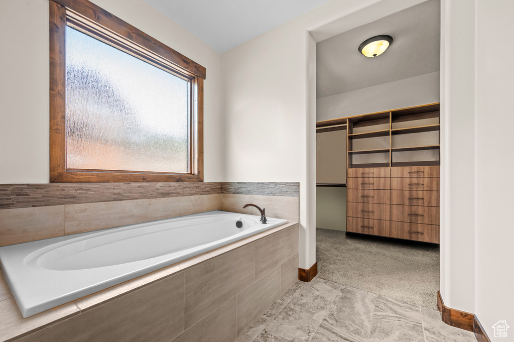 Bathroom with tile floors and tiled tub